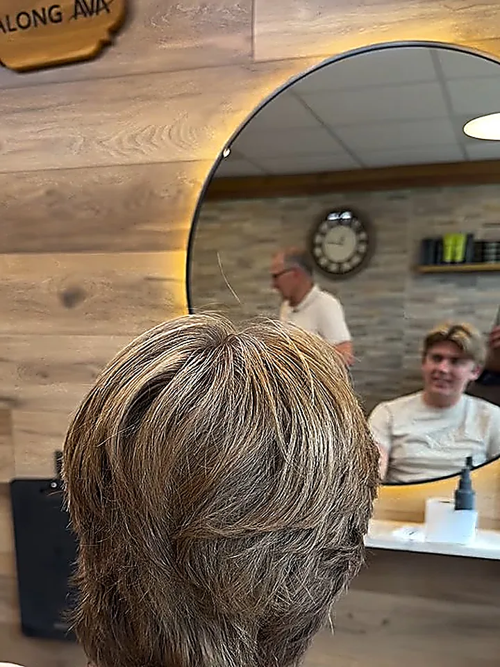 Lagerklippt hår med ljusa slingor, sett bakifrån i salongen