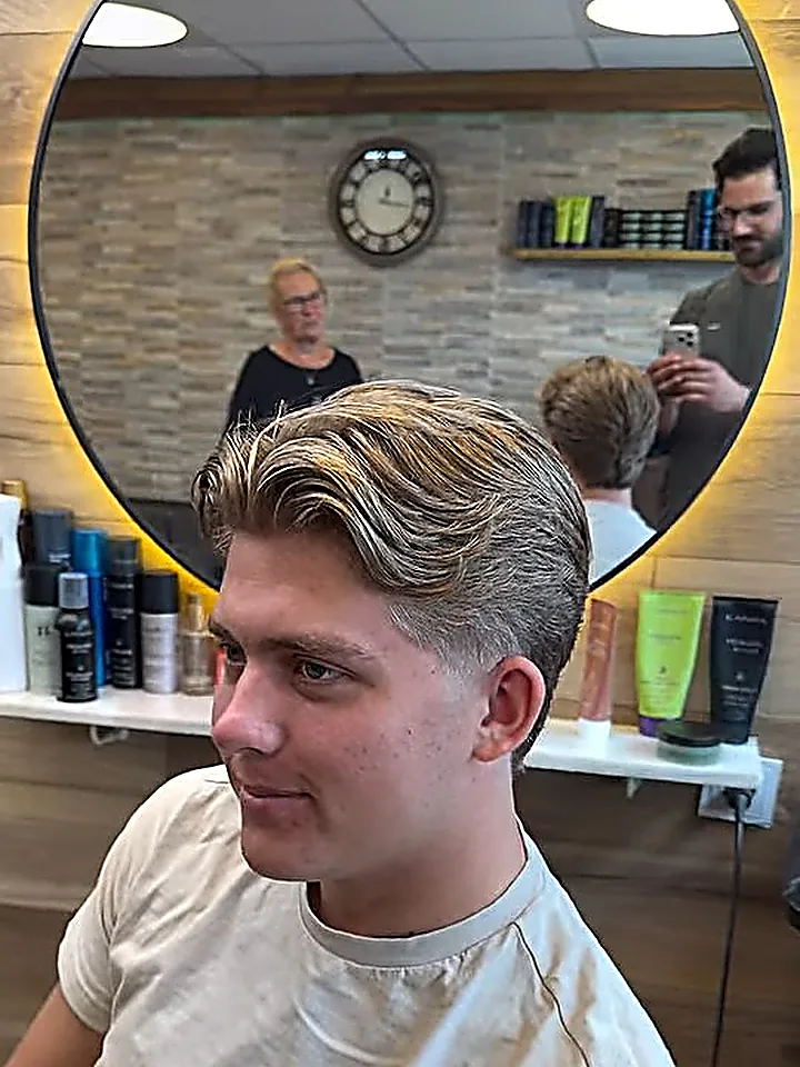 Herrklippning med bakåtkammad volym och toning på sidorna